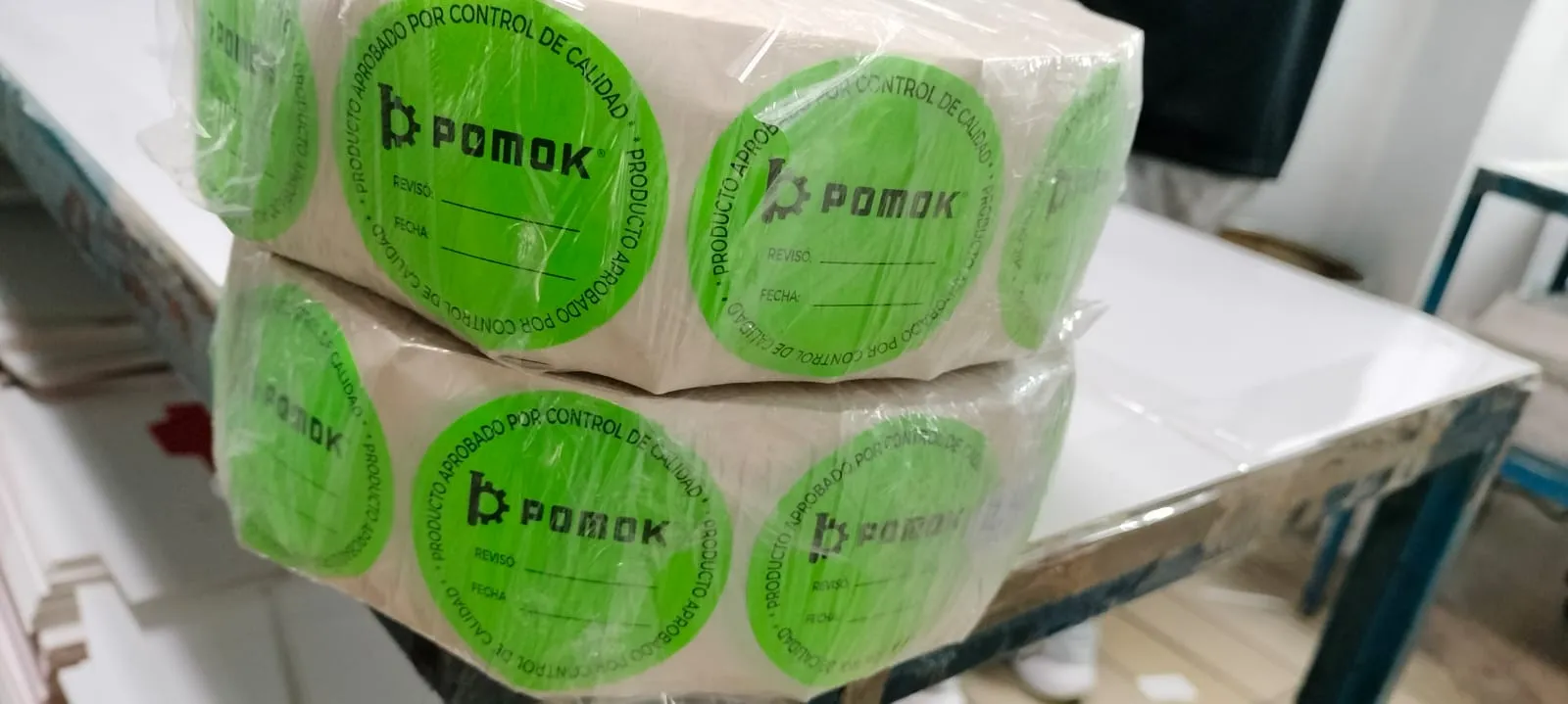 Fábrica de etiquetas: Fotografía de un rollo de etiquetas autoadheribles color verde con letras en color negro.